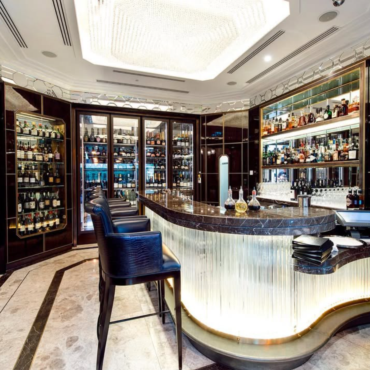 Luxurious bar with marble counter and wine bottles in a high-end setting